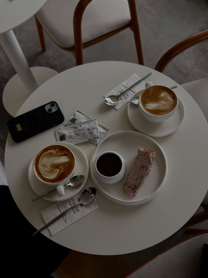 Top view of a minimalist coffee table with cappuccinos and dessert, creating a warm and inviting ambiance.