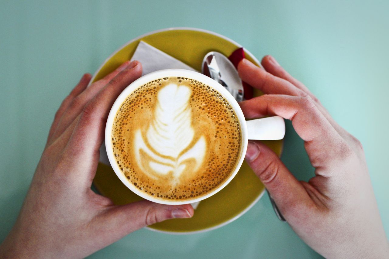 Discover the art and warmth of coffee with this beautifully crafted latte adorned with delicate foam art in a cozy café setting.